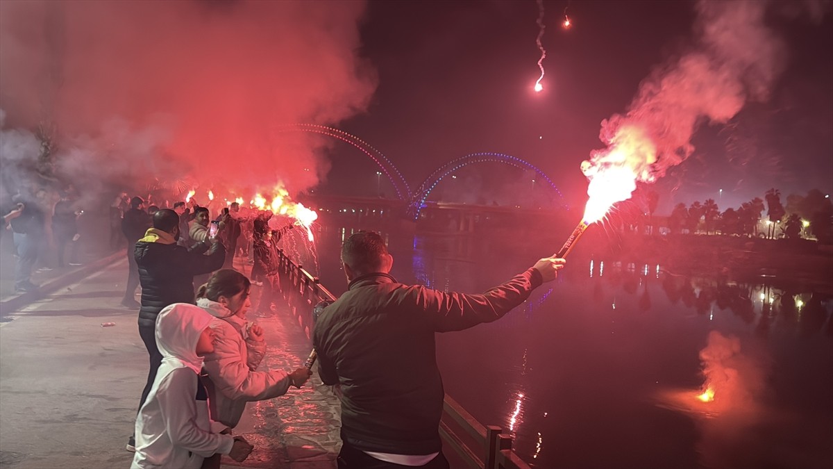 Adana'da Seyhan Nehri kıyısında toplanan Adana Demirspor taraftarları, havai fişek atarak...