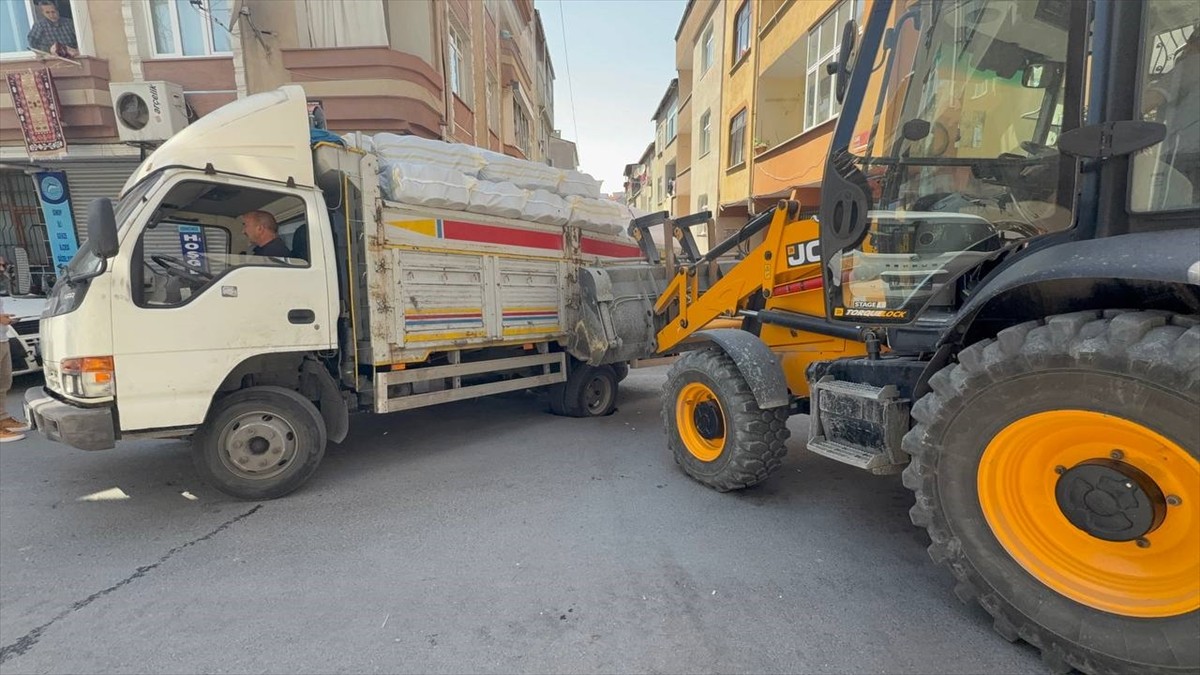 Esenler'de sol arka lastiği yolda oluşan çukura giren kamyon, iş makinesi yardımıyla...