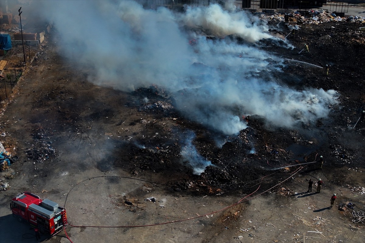 İzmir'in Buca ilçesinde boş alandaki atık yığınında çıkan yangın, itfaiye ekiplerince...